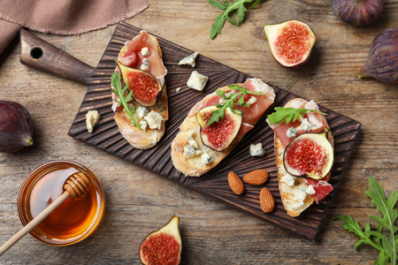Sandwiches with ripe figs and prosciutto served on wooden table, flat layの写真素材
