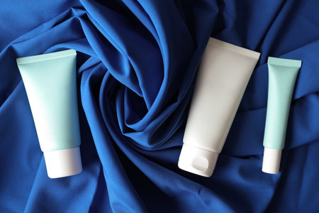 Set of luxury cosmetic products on blue fabric, flat layの写真素材