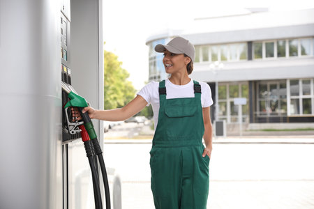 Worker taking fuel pump nozzle at modern gas stationの写真素材