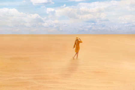 woman walking in desert on sunny dayの写真素材