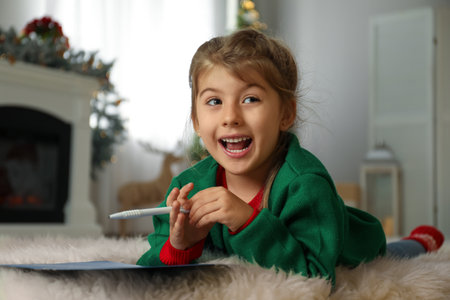 Cute child writing letter to Santa Claus at home. christmas traditionの写真素材