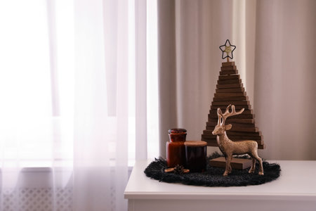 Composition with decorative Christmas tree and reindeer near window, space for textの写真素材