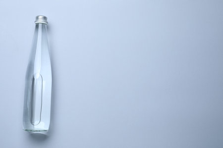 Glass bottle with water on white background, top view. Space for textの写真素材