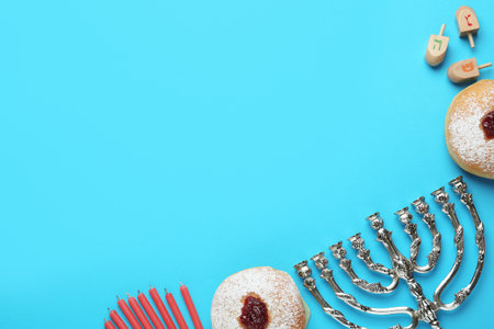 Hanukkah traditional menorah, candles, donuts, dreidels with letters He, Pe, Nun, Gimel on light...