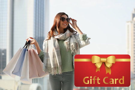 Store gift card. Happy woman with shopping bagsの写真素材