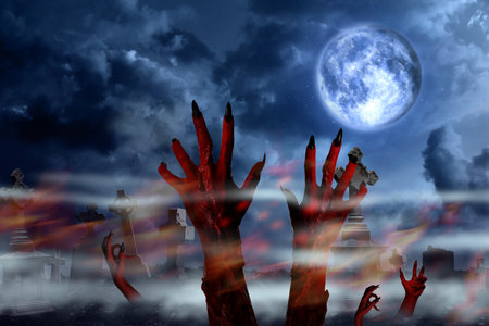 Scary monsters arising from graves at old misty cemetery under full moon on Halloween nightの写真素材