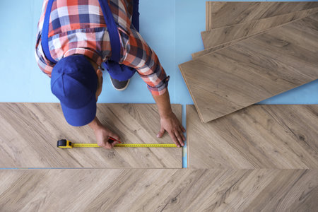 Worker installing laminated wooden floor indoors, above viewの写真素材