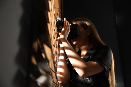 Private detective with camera spying near window indoorsの写真素材