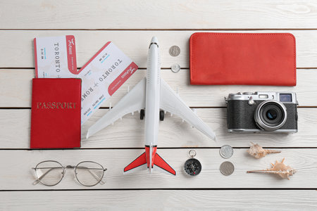 Flat lay composition with toy airplane and travel items on white wooden backgroundの写真素材