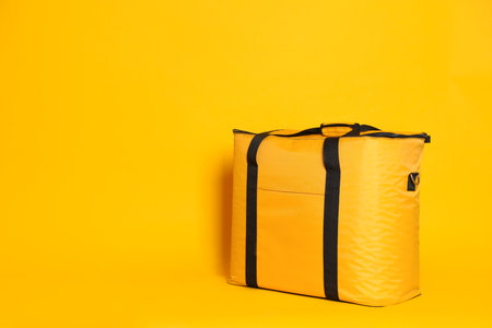 Modern thermo bag on yellow background. Space for textの写真素材