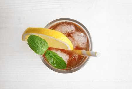 Delicious iced tea with lemon and mint on white wooden table, top viewの写真素材