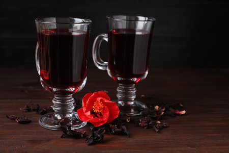 Delicious hibiscus tea and dry flowers on wooden tableの写真素材