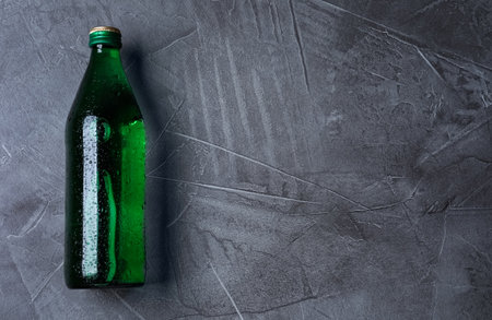 Glass bottle with water on black background, top view. Space for textの写真素材