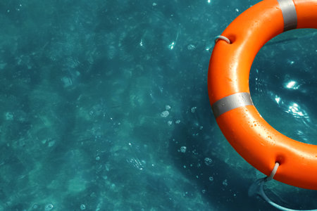 Orange life buoy floating in the sea, above view. emergency rescue equipment