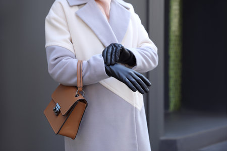Woman with leather gloves and stylish bag outdoors, closeupの写真素材