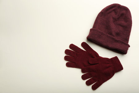 Woolen gloves and hat on beige background, flat lay. Space for textの写真素材