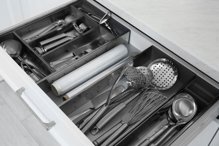 Open drawer with stainless steel utensil set, closeup. Order in kitchenの写真素材