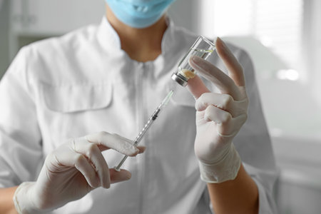 Doctor filling syringe with medication in clinic, closeup. Vaccination and immunizationの写真素材