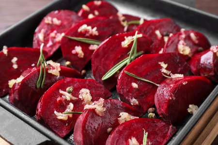 Raw beetroot slices, garlic and rosemary in baking dish, closeupの写真素材