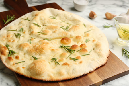 Delicious focaccia bread on wooden board, closeupの写真素材