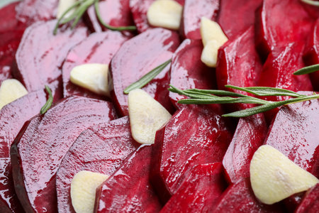 Raw beetroot slices, garlic and rosemary as background, closeupの写真素材