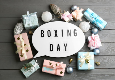Flat lay composition with Boxing Day sign and Christmas gifts on gray wooden tableの写真素材