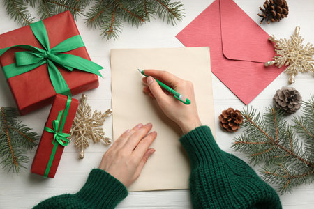 Woman writing letter to Santa at white wooden table, top viewの写真素材