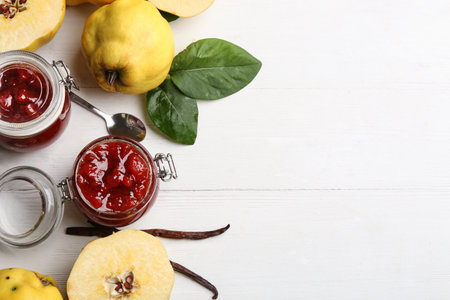 Delicious quince jam and fruits on white wooden table, flat lay. Space for textの写真素材