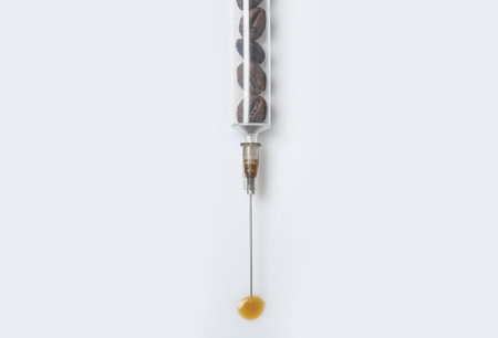 Syringe full of coffee beans on white background, top view. Caffeine addiction conceptの写真素材