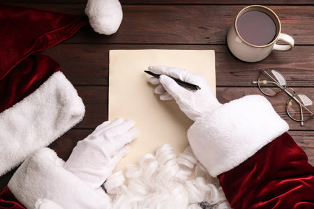 Top view of Santa writing letter on wooden table, closeupの写真素材