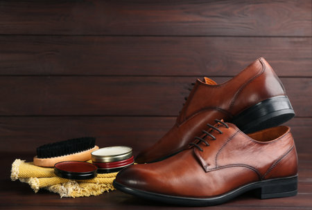 Shoe care products and footwear on wooden table. Space for textの写真素材