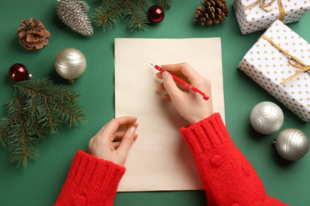 Top view of woman writing letter to Santa at green table, closeupの写真素材