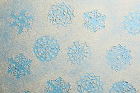 Snowflakes made of flour on light blue background, top viewの写真素材