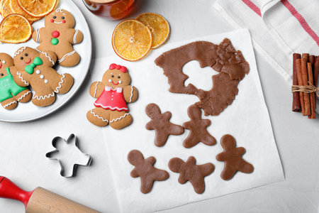 Flat lay composition with homemade gingerbread man cookies on light table
