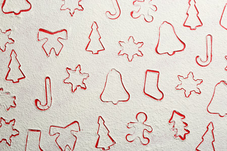Different Christmas cookie shapes made of flour on red background, top view