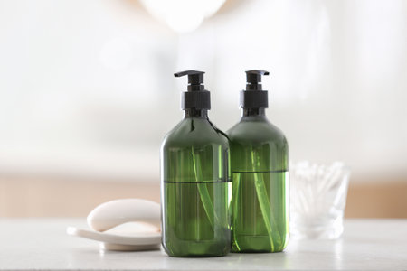 Green soap dispensers on white countertop in bathroomの写真素材