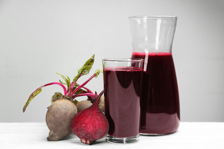 Fresh beet juice and raw vegetable on white wooden tableの写真素材