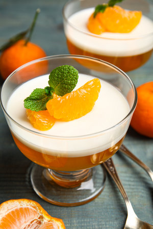 Delicious tangerine jelly on light blue wooden table, closeupの写真素材
