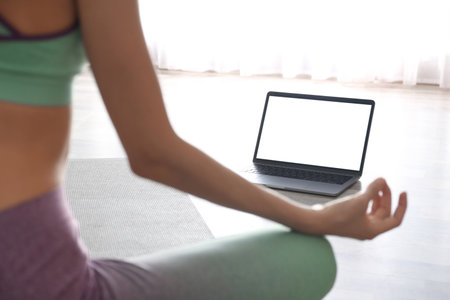 Woman having online video class via laptop at home, closeup. Distance yoga course during   pandemicの写真素材