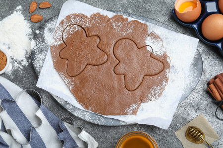 Flat lay composition with homemade gingerbread man cookies on gray table