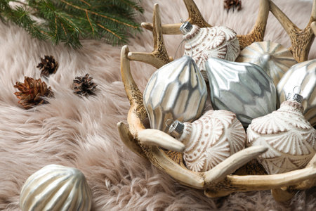 Composition with beautiful Christmas baubles on beige furの写真素材
