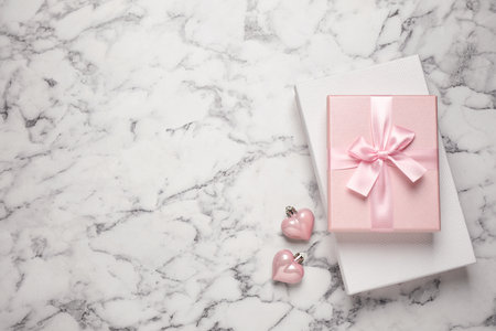Beautiful gift boxes and festive decor on white marble table, flat lay. Space for textの写真素材