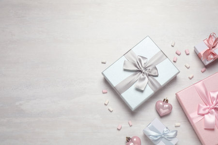 Beautiful gift boxes and festive decor on white table, flat lay. Space for textの写真素材