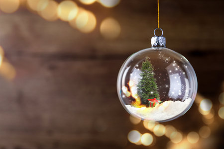 Beautiful glass ball with Christmas tree and gift on blurred background, space for text. bokeh effectの写真素材
