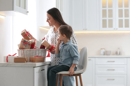 Mother and son with Christmas gifts at home. advent calendar in basketの写真素材