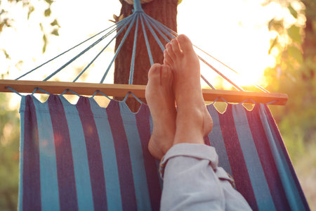 Man resting in comfortable hammock at green garden, closeupの写真素材