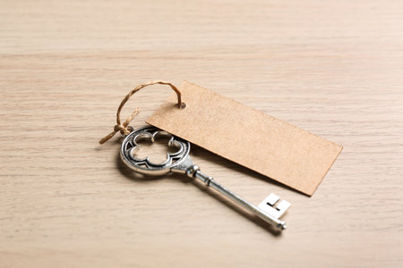 Key with blank tag on wooden table. Keyword conceptの写真素材