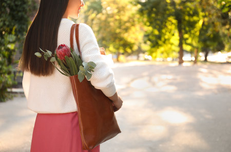 Woman with leather shopper bag in park, closeupの写真素材