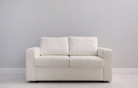 Comfortable white sofa near light wall indoors, space for text. simple interiorの写真素材