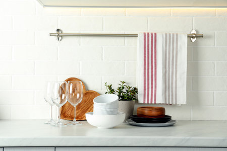 Set of clean tableware on white countertop in kitchenの写真素材